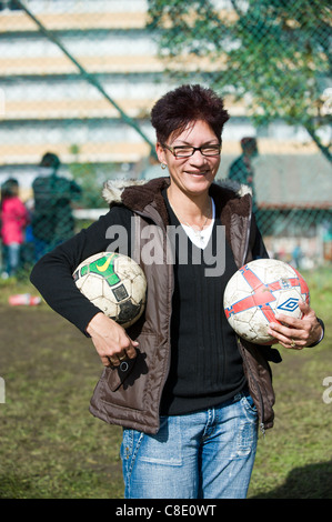 Sostenitore portante due palloni da calcio Rygersdal football club Città del Capo Sud Africa Foto Stock