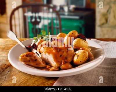 Tradizionale poachers pollo casseruola pasto servito con patate novelle su un piatto in un ambiente rustico casa cucina Foto Stock