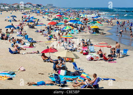 Le persone in vacanza e nuotare in un giorno di estate in spiaggia. Foto Stock