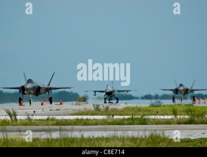 Due F-35A Lightning II joint strike fighter e un F-16 Fighting Falcon taxi sulla pista dopo l'arrivo a Eglin Foto Stock