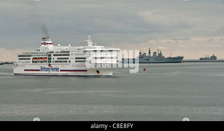 A Brittany Ferries nave passeggeri della cottura a vapore nella porta con HMS illustre in background. Foto Stock