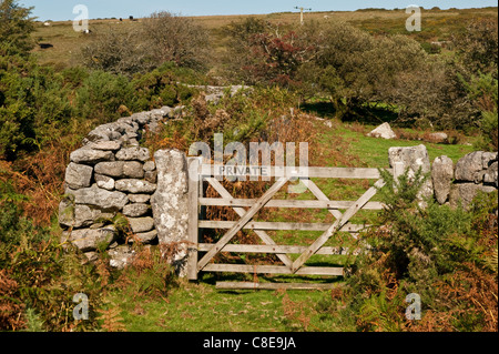 Un agricoltore in legno porta contrassegnata con 'private' con un secco muro di pietra della curvatura lontano da un lato su una collina. Foto Stock