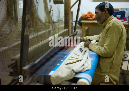 Indian uomo telaio di lavoro alla fabbrica di seta rendendo i tessili e dei sari a Bressler vicino a Varanasi, Benares, India settentrionale Foto Stock
