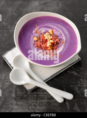 Crema di Vitelotte zuppa di patate con nocciole frantumate e fiocchi di carne dei Grigioni Foto Stock