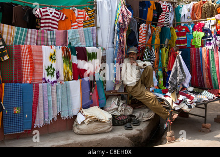 Stallholder vendono vestiti e sari tessuti e altri prodotti tessili a Varanasi, India settentrionale Foto Stock