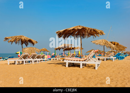 Orizzontale spiaggia di Calangute scena baracche di lettini per il sole di sabbia ombrelloni spiaggia mare blue skies margini di ritaglio spazio copia gli spazi vuoti Foto Stock