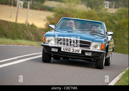 Classico degli anni ottanta, Mercedes Benz 280 SL auto viene guidato su una strada in Inghilterra. Foto Stock