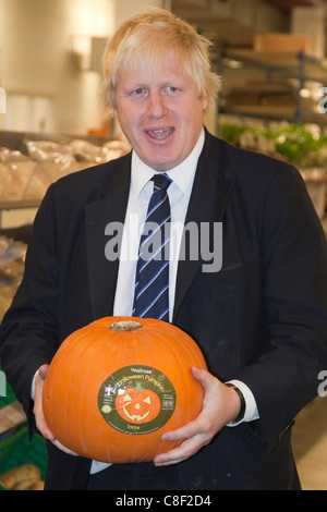 21/10/2011. Londra, Regno Unito. Il sindaco di Londra Boris Johnson detiene una zucca come egli visiti il nuovo Waitrose online centro di distribuzione a Acton, dove ha preso un tour e si è incontrato con il personale e i partner Waitrose. Boris Johnson tenendo una zucca. Foto Stock