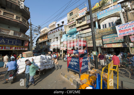 Facchini in mezzo al traffico in corrispondenza della giunzione di Khari Baoli Road, (Spice Market Bazar off Chandni Chowk), la Vecchia Delhi, India Foto Stock