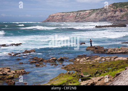 Uomo a riva la pesca- west coast vicino Lorinho Foto Stock