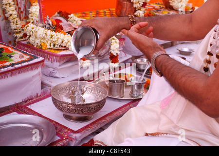 La balneazione una statua della dea Durga con il latte durante la puja in un tempio indù, Haridwar, India Foto Stock