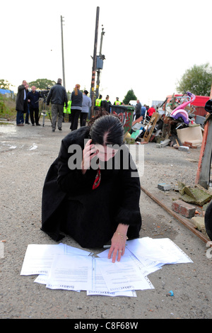 Candy Sheridan, attivista per i diritti degli zingari, studi gli avvisi di sfratto che sono state fissate alla proprietà e tenute sul sito di viaggiatori a Dale Farm, Crays Hill, vicino a Basildon, Essex, Regno Unito Foto Stock