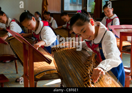 Le ragazze giovani suonare gli strumenti tradizionali nel palazzo Schoolchildrens, Pyongyang, Corea del Nord Foto Stock