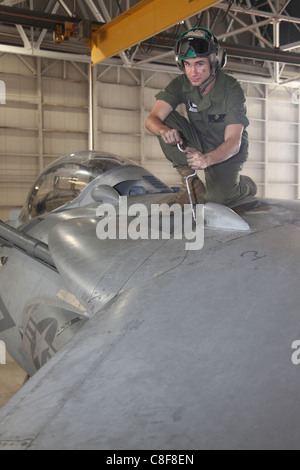 Una cellula meccanico per attacco Marino Squadron 231, funziona su un AV-8B Harrier in lo squadrone appendiabiti 20 giugno. Foto Stock