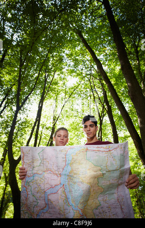 Giovane uomo e donna controllo mappa durante escursioni di trekking e di cercare la destinazione. Forma verticale, a basso angolo di visione Foto Stock