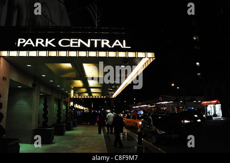 Notte tempo-shot neon Park Central Hotel ingresso tettoia, gente camminare il marciapiede, taxi auto parcheggiate sul ciglio della strada, 7th Avenue, New York Foto Stock