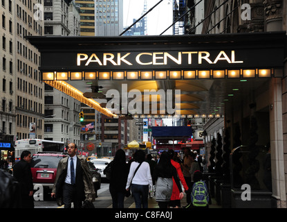 Pomeriggio piovoso rush-ora visualizzare il traffico di persone a piedi illuminato sul marciapiede Park Central Hotel tettoia, 7th Avenue, New York Foto Stock