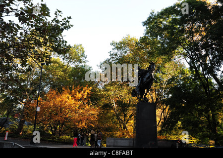 Autunno soleggiata vista verso la golden verdi alberi Jose Marti statua seduta a cavallo, artisti' Gate, Central Park South, New York Foto Stock