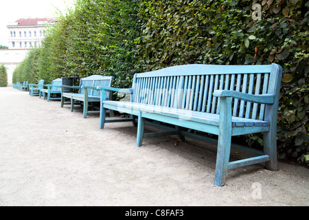 Fila di panchine lungo la strada del parco Foto Stock