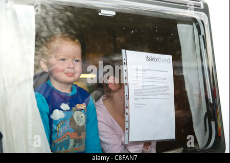 Il 21 ottobre 2011. Due giovani bambini guardano fuori da una finestra di viaggiatori una carovana di Dale Farm vicino a Basildon, Essex, dopo un avviso di sfratto è stato bloccato sulla finestra da un consiglio di Basildon officer. Dopo dieci anni di battaglia legale per i viaggiatori sono ora in procinto di essere espulse. Foto Stock