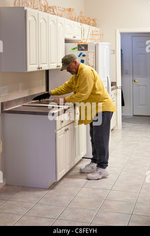 L'uomo costruisce un modello in legno per impiego nella realizzazione del nuovo piano in granito sostituzioni per cucina residenziale Foto Stock