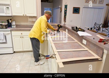 L'uomo costruisce un modello in legno per impiego nella realizzazione del nuovo piano in granito sostituzioni per cucina residenziale Foto Stock