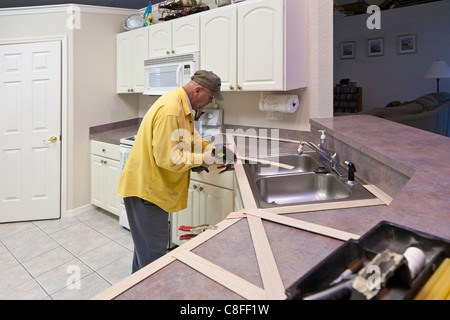 L'uomo costruisce un modello in legno per impiego nella realizzazione del nuovo piano in granito sostituzioni per cucina residenziale Foto Stock