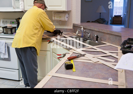 L'uomo costruisce un modello in legno per impiego nella realizzazione del nuovo piano in granito sostituzioni per cucina residenziale Foto Stock