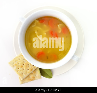 Zuppa di noodle al pollo in una tazza bianca con cracker Foto Stock