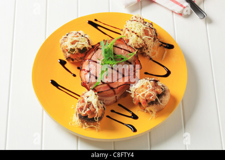 Funghi ripieni con la carne di suolo e filetto di maiale avvolto in pancetta Foto Stock