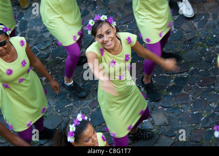 Signora giovane danze su strada stretta con la truppa di danza in verde chiaro abiti. Foto Stock