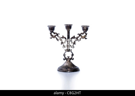 Vecchio opacizzato argento candelabro con un lieve riflesso/ombra su uno sfondo bianco. Foto Stock