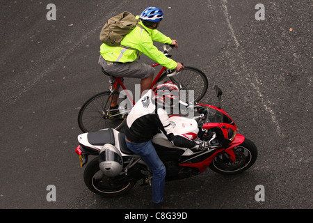 Guardando verso il basso su un ciclista e moto rider in attesa in corrispondenza di un incrocio a Londra Foto Stock