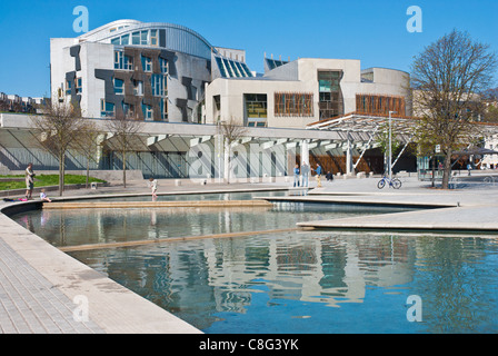 Il Parlamento scozzese di Edimburgo. Suggestiva architettura. I colori luminosi e cielo blu chiaro riflesso nel lago in primo piano Foto Stock