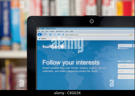 Il sito web di Twitter sparato contro una libreria sullo sfondo (solo uso editoriale: -print, TV, e-book e Redazione sito web). Foto Stock