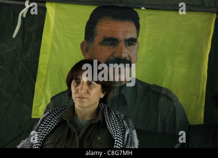 Ritratto del Kurdistan Comunità europea (KCK) Consiglio esecutivo degli Stati Sozdar Avesta con la figura di ex militanti del PKK leader Abdullah Ocalan in background in un covo del PKK camp Iraq settentrionale Foto Stock