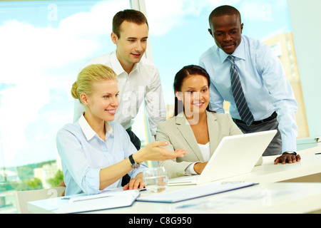 Imprenditrice mostrando qualcosa ai suoi colleghi Foto Stock