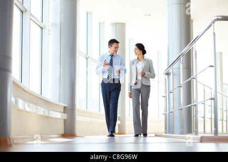 Fiducioso business partner per camminare in edificio per uffici e parlare Foto Stock