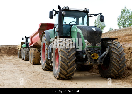 Trattore verde con gruccia sul sito in costruzione Foto Stock