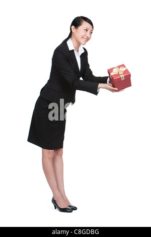Felice imprenditrice tenendo un dono Foto Stock
