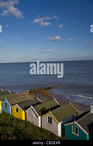 Pittoresca spiaggia di capanne guarda il mare sotto un luminoso cielo blu a Southwold in Suffolk Foto Stock