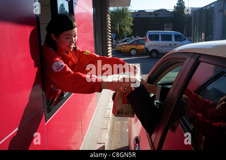 Un dipendente cinese serve un autista in un McDonald drive thru a Pechino in Cina. 23-ott-2011 Foto Stock