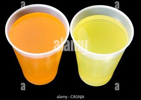 Due bicchieri di plastica di colore giallo e con liquido arancione. Foto Stock