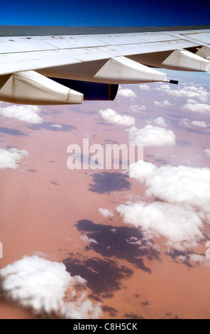 Un getto ala sorvola il Sahara, come le nuvole proiettano ombre sulla sabbia Foto Stock