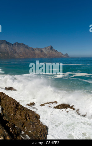 La frantumazione delle onde sui massi lungo il percorso 44 False Bay Western Cape Sud Africa Foto Stock