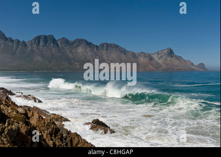 La frantumazione delle onde sui massi lungo il percorso 44 Western Cape Sud Africa Foto Stock