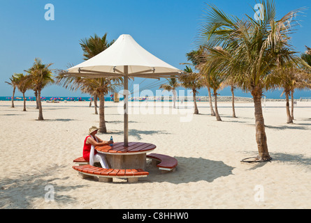 Turista femminile, ombrelloni, Russo di Jumeirah Beach, Dubai, Emirati Arabi Uniti, Emirati arabi uniti Foto Stock