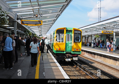 Il treno sta per lasciare Chichester stazione ferroviaria. Persone su piattaforme. Foto Stock