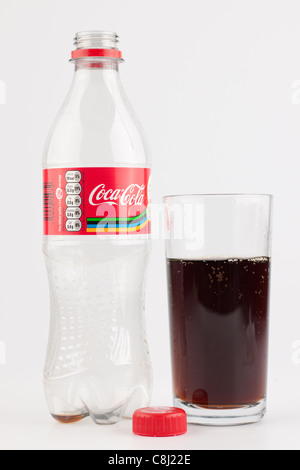 Svuotare la bottiglia di plastica di Coca Cola e una parzialmente riempita di vetro liscio Foto Stock