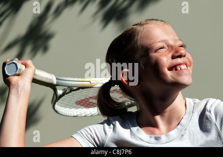 Fiducioso elementari di età ragazza sul campo da tennis. Foto Stock